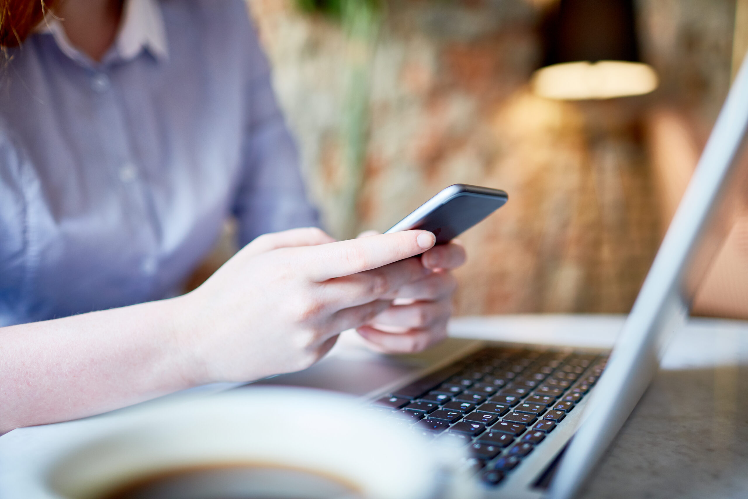 Contemporary female with modern gadgets texting or browsing in the net